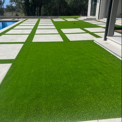 Concrete slabs and artificial grass create a clean yard space.