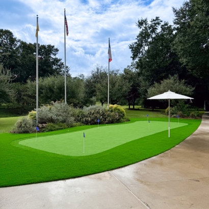 Artificial turf putting green with flags and an umbrella.