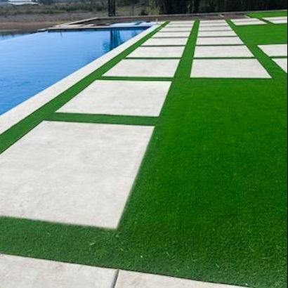 Concrete pavers and artificial grass by a pool.