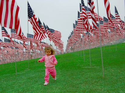 child pink girl American flags runs artificial grass