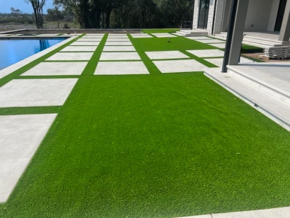 Concrete slabs and artificial grass create a clean yard space.