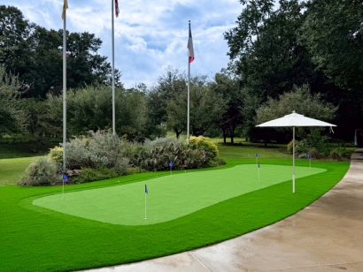 Artificial turf putting green with flags and an umbrella.